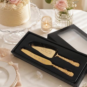 Conjunto de facas para bolo de casamento personalizadas em ouro, com cabos gravados com motivos florais em relevo.