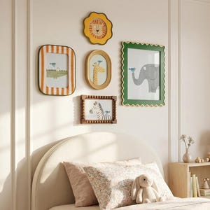 May include: A child's bedroom with framed animal art on the wall above a bed. The art includes a lion, giraffe, elephant, crocodile, and zebra. The bed has a pink quilt, pillows, and a stuffed bunny.