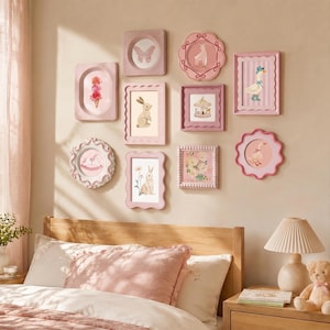 Könnte beinhalten: Eine Galeriewand mit zehn rosafarbenen Rahmen in verschiedenen Formen und Größen, darunter gewellte, rechteckige und ovale Designs. Die Rahmen enthalten Illustrationen von Tieren, Blumen und Karussellmotiven auf einer hellen Wand.