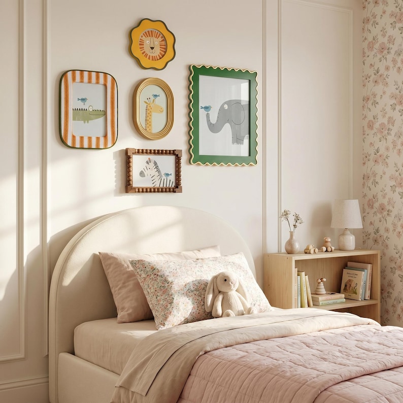 May include: A child's bedroom with framed animal art on the wall above a bed. The art includes a lion, giraffe, elephant, crocodile, and zebra. The bed has a pink quilt, pillows, and a stuffed bunny.