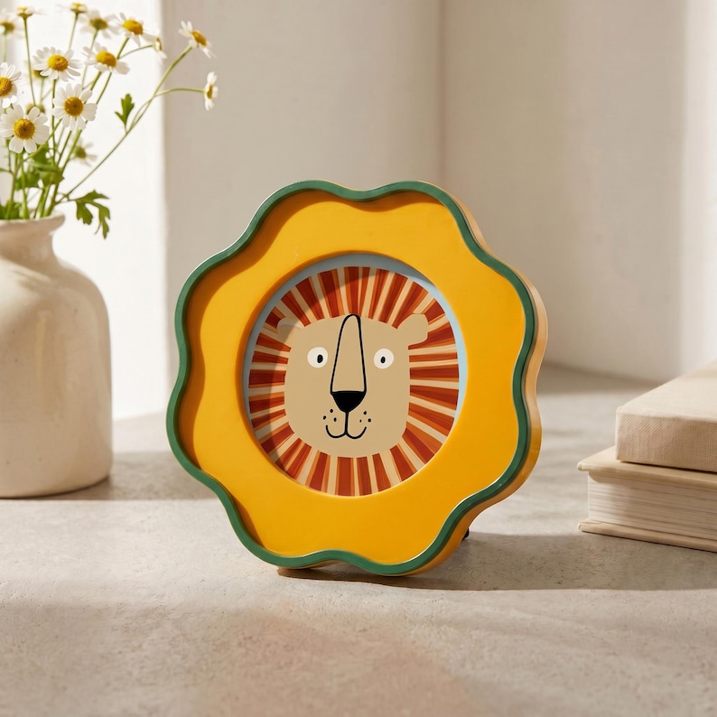 K&ouml;nnte beinhalten: Eine runde, blumenf&ouml;rmige Uhr mit gelbem Rahmen und dunkelgr&uuml;nem Rand. Das Zifferblatt zeigt eine zentrale Illustration eines L&ouml;wengesichts mit beiger Schnauze, schwarzer Nase und einer M&auml;hne aus abwechselnden orangefarbenen und braunen Streifen.