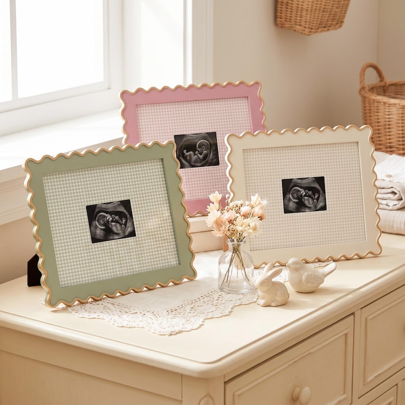Puede incluir: Tres marcos de fotos rectangulares con bordes festoneados en verde salvia, rosa suave y crema. Cada marco presenta un paspart&uacute; con patr&oacute;n de cuadros vichy y una ecograf&iacute;a en blanco y negro. Un peque&ntilde;o jarr&oacute;n de cristal con flores secas.