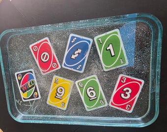 Bandeja para liar de resina epoxi con cartas de Uno y purpurina plateada – Arte en resina azul translúcida