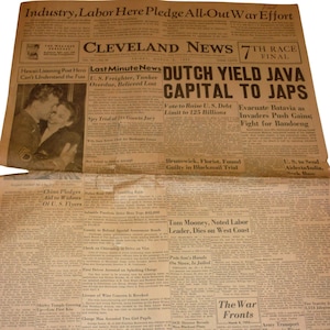 Peut inclure: Un journal Cleveland News daté du vendredi 6 mars 1942. La une présente des titres en gras tels que Industry, Labor Here Pledge All-Out War Effort et Dutch Yield Java Capital to Japs, avec une photographie en noir et blanc d'un couple.