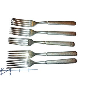 Puede incluir: Cinco tenedores antiguos de plata con púas y mangos texturizados están dispuestos horizontalmente. Los tenedores son de metal color plata y tienen un aspecto vintage. Los mangos tienen un aspecto ligeramente deslustrado, lo que sugiere edad y uso. Los tenedores son un juego de cubiertos.