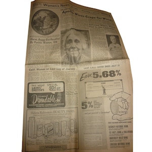May include: A vintage newspaper page with headlines like "Women's News" and "Apollo Wives Grope for Words." It features articles, advertisements for "Dependable" cleaners, and Helena Rubinstein beauty products. The paper is aged with a yellowed tone.