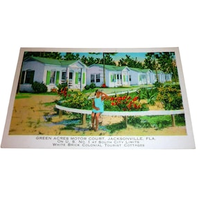 Pode incluir: Postal vintage com Green Acres Motor Court em Jacksonville, Flórida. A imagem mostra casas de turismo coloniais de tijolo branco com persianas verdes. O texto no postal diz "Green Acres Motor Court, Jacksonville, Fla."