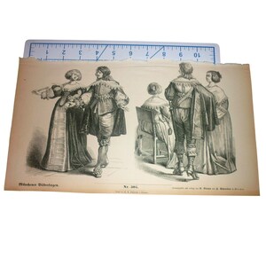 May include: A black and white historical print titled Münchner Bilderbogen Nr. 305, depicting four figures in period clothing. A blue ruler is placed along the top edge, showing a width of 10 inches. The print features detailed illustrations of individuals in elaborate garments.