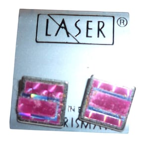 May include: A pair of square earrings with a pink, iridescent design and silver-colored frames. The earrings are displayed on a light gray card with the word "LASER" printed in black.