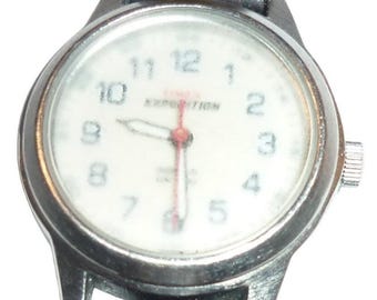 Orologio Timex Expedition Indiglo con quadrante bianco, cinturino in pelle marrone, impermeabile fino a 50 metri e cassa da 26 mm.