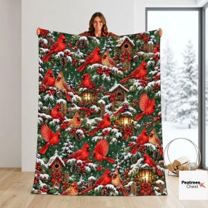 May include: A rectangular throw blanket featuring a repeating winter pattern of bright red cardinals, snow-covered pine branches, red berries, and rustic wooden birdhouses with glowing lanterns against a deep forest green background.