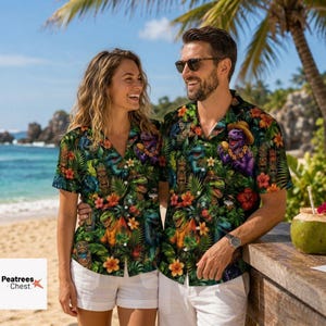 May include: Two short-sleeved button-down shirts featuring a vibrant tropical print with green palm leaves, colorful hibiscus flowers, and cartoon dinosaurs wearing hats. The shirts have a dark background and a classic collar design.