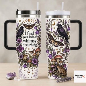 May include: Two white stainless steel tumblers with black handles and straws, featuring illustrations of black ravens, moths, purple flowers, mushrooms, and toads. The left tumbler displays the text, I find your lack of whimsy disturbing.