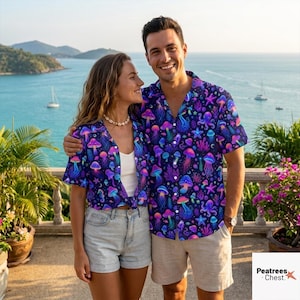 May include: Two short-sleeved button-down shirts featuring a vibrant, neon-colored pattern of jellyfish, mushrooms, and sea life against a dark navy blue background. The shirts have a classic collar and a button-up front, showcasing a colorful print.