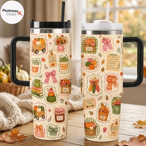 May include: Two stainless steel tumblers with black handles and straws, featuring a cream-colored background with a repeating pattern of autumn-themed illustrations including pumpkins, sunflowers, plaid bows, scarves, and fall-related text labels.