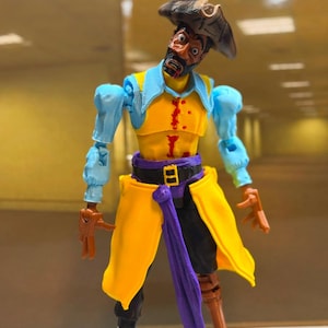 May include: A pirate action figure with a dark brown hat, light blue shirt, and yellow vest featuring red paint splatters. The figure has a purple sash, black trousers, a brown peg leg, and a black boot. The face has a beard and wide eyes.