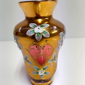 Vintage boho vaas van robijnroze glas, rijkelijk versierd met goudkleurige en geëmailleerde bloemen, klein Tsjechisch tafelstuk.