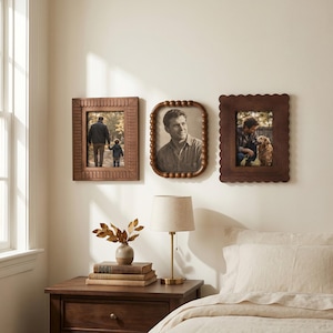 May include: Three rectangular wall-mounted picture frames with distinct wooden borders. The left frame has a linear carved pattern, the center frame features a rounded beaded edge, and the right frame has a scalloped edge. Each holds a photograph.