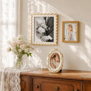 May include: Two rectangular wall-mounted picture frames and one oval tabletop picture frame. The larger rectangular frame has a wavy gold edge, the smaller rectangular frame has a beaded gold edge, and the oval frame is white with gold accents.