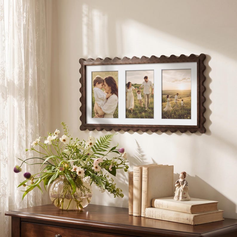 May include: A rectangular dark brown wooden picture frame with a scalloped edge design. The frame features three vertical openings with white matting, each displaying a photograph of a family in an outdoor setting during the golden hour.
