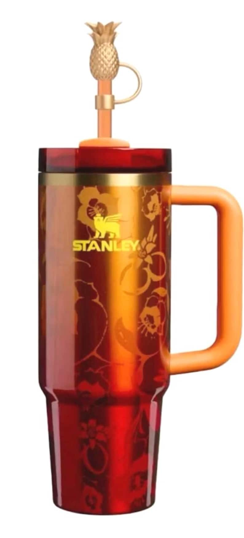 K&ouml;nnte beinhalten: Ein Stanley-Reisebecher mit goldenem Ananas-Aufsatz und Griff. Der Becher ist rot und orange mit einem floralen Design und dem Stanley-Logo. Der Griff und der Strohhalm sind orange.