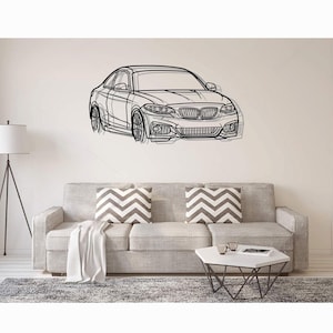 以下が含まれることがあります： BMWクーペを描いた黒いラインアートのウォールステッカー。特徴的なキドニーグリル、ヘッドライト、ホイールを含む詳細な正面図が、壁面にグラフィックイラストとして表現されています。