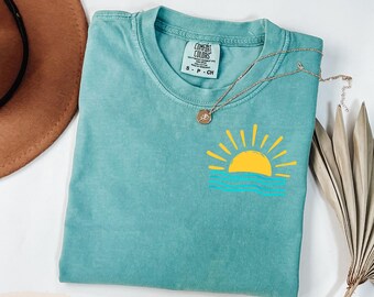 Camiseta Comfort Colors con estampado de sol y olas de verano, ideal para vacaciones en la playa.