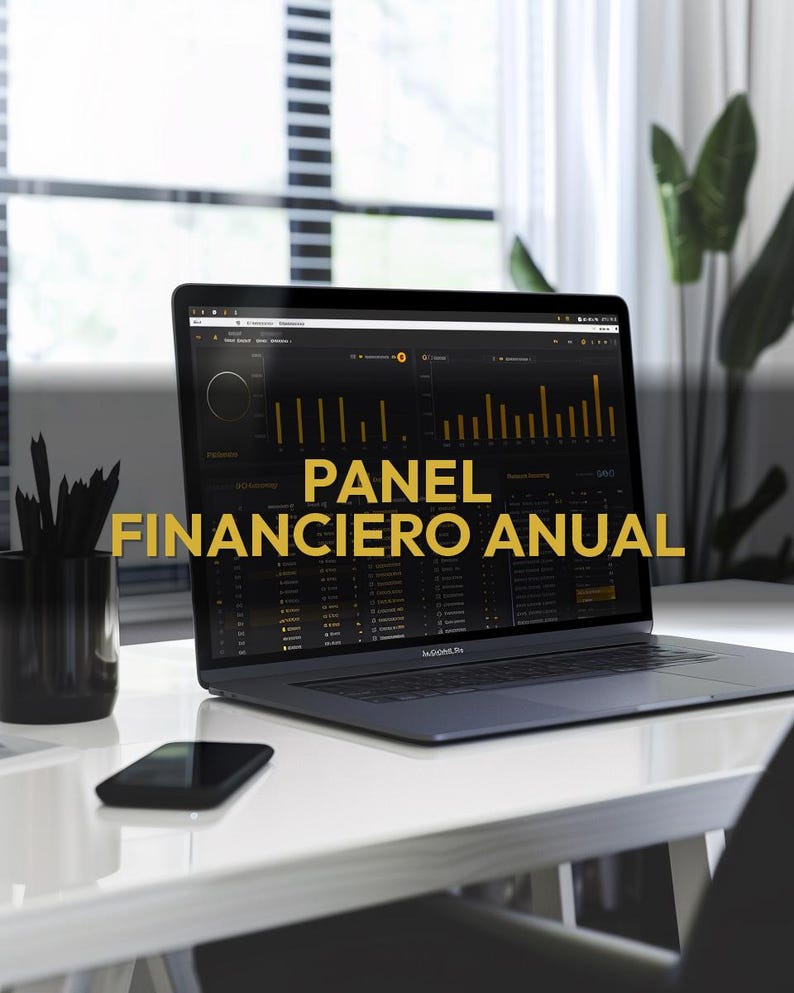 May include: A laptop displaying a financial dashboard with the text "PANEL FINANCIERO ANUAL" in gold. The laptop is on a white desk with a black smartphone and a black pencil holder. A window and a plant are in the background.