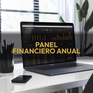 May include: A laptop displaying a financial dashboard with the text "PANEL FINANCIERO ANUAL" in gold. The laptop is on a white desk with a black smartphone and a black pencil holder. A window and a plant are in the background.