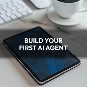 May include: A black tablet with the text "BUILD YOUR FIRST AI AGENT" is the focal point of this image. A white keyboard, mouse, and a cup of coffee on a saucer are also visible. The tablet has a dark blue geometric design on the screen.