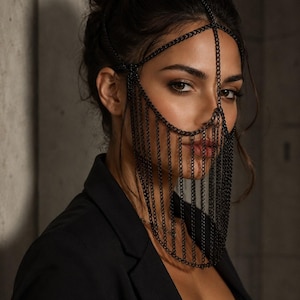 May include: A black metal chain headpiece featuring a delicate lattice design that frames the upper face and forehead, with multiple vertical chain strands cascading down to cover the nose and mouth area, creating a fringe effect across the lower face.