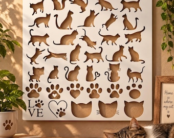 Könnte beinhalten: Eine weiße quadratische Wandplatte mit lasergeschnittenen Silhouetten verschiedener Katzen in unterschiedlichen Posen, Pfotenabdrücken und Herzformen. In der unteren linken Ecke befindet sich der Text LOVE mit einem Pfotenabdruck statt des O.