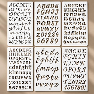 Può includere: Sei stencil rettangolari in plastica bianca con vari caratteri ritagliati, tra cui lettere maiuscole e minuscole, numeri e simboli. Ogni foglio mostra uno stile di carattere distinto, che spazia dal corsivo al carattere stampatello.
