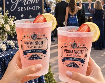 Può includere: Due bicchieri di plastica trasparente riempiti con una bevanda rosa, guarniti con una fetta di fragola e uno spicchio di limone. I bicchieri presentano una grafica blu scuro con una palla da discoteca, stelle e il testo: PROM NIGHT CLASS OF 2027 MAKE IT A MOMENT.