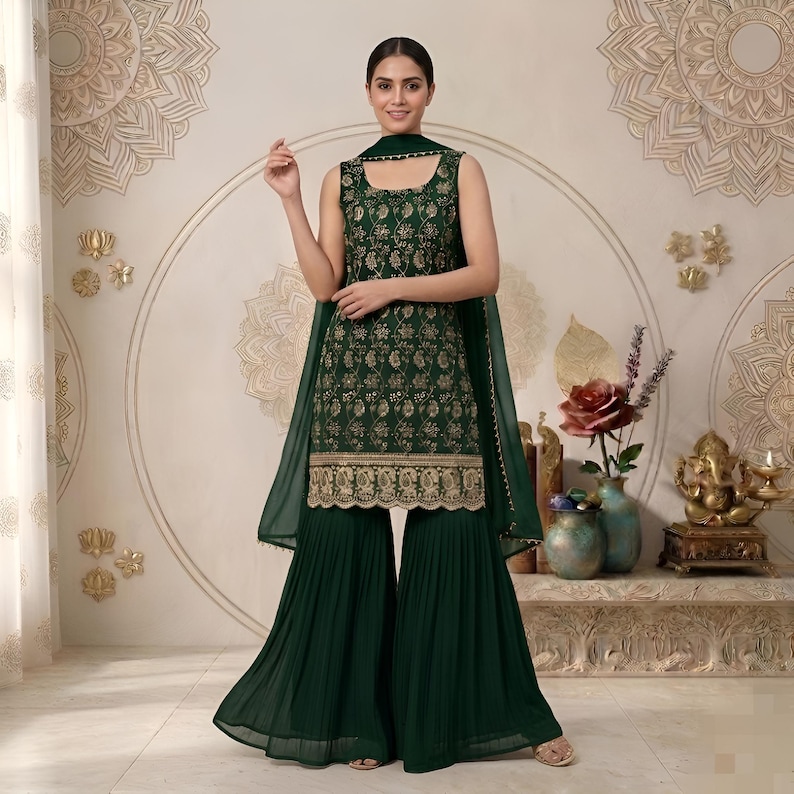 May include: A dark green sleeveless tunic featuring intricate gold floral embroidery and a scalloped hem, paired with matching dark green pleated wide-leg trousers and a coordinating sheer dark green dupatta draped over the shoulders.
