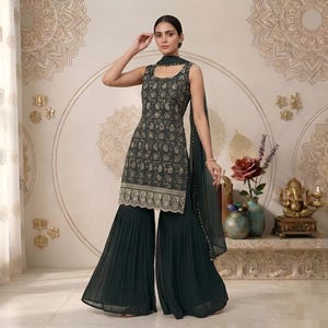 May include: A dark green sleeveless tunic featuring intricate gold floral embroidery and a scalloped hem, paired with matching dark green pleated wide-leg trousers and a sheer dark green dupatta draped over one shoulder with gold trim detailing.