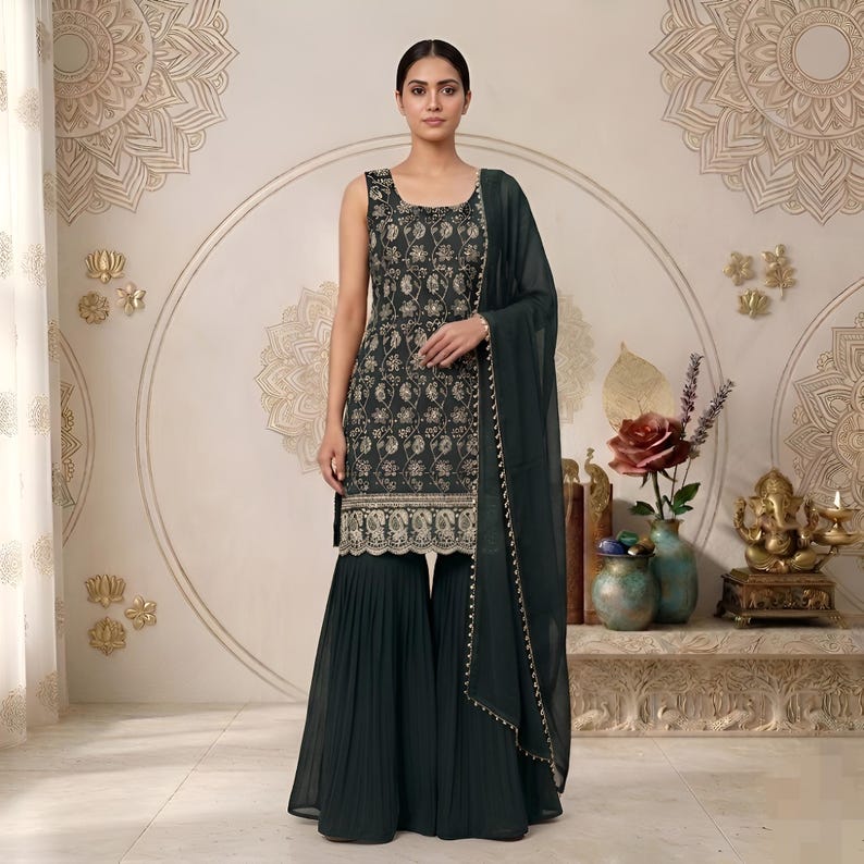 May include: A dark green sleeveless tunic featuring intricate gold floral embroidery and a scalloped hem, paired with matching dark green pleated wide-leg trousers and a sheer dark green dupatta with a delicate gold beaded border trim.