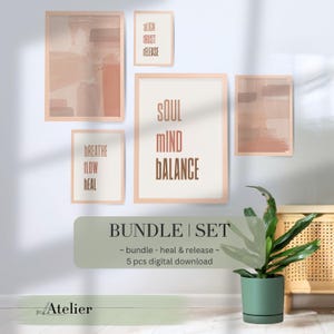 Könnte beinhalten: Ein Set aus fünf gerahmten Kunstdrucken in einer neutralen Farbpalette. Die Drucke zeigen abstrakte Pinselstrich-Designs und inspirierende Texte wie "Soul Mind Balance" und "Breathe Flow Heal". Eine grüne Pflanze in einem Topf befindet sich im Vordergrund.