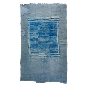 May include: A vintage blue and white rug with a faded design. The rug has a distressed look and is made of a soft, woven material.