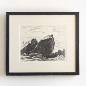 May include: A black and white print of a seascape with two large rocks in the foreground and a cloudy sky in the background.