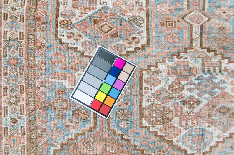 Puede incluir: Un primer plano de una alfombra de color azul claro y rosa con una tabla de colores de referencia. La alfombra tiene un dise&ntilde;o tradicional con detalles intrincados.
