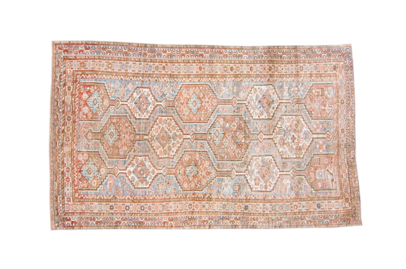 Puede incluir: Una alfombra vintage con un patr&oacute;n geom&eacute;trico en tonos rojos, azules y blancos. La alfombra tiene un medall&oacute;n central y un borde con detalles intrincados.