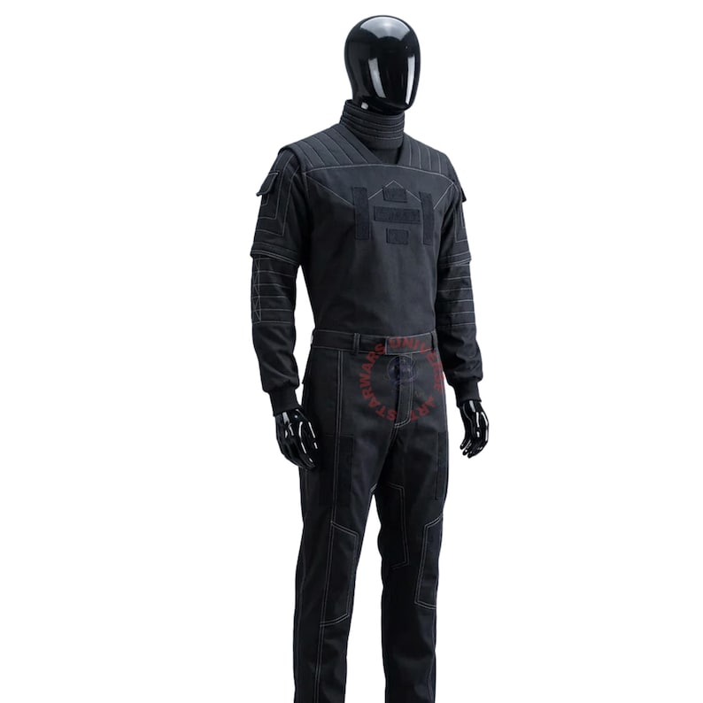 May include: A black long-sleeved tactical jumpsuit featuring a high ribbed collar, quilted shoulder panels, and white contrast stitching throughout. The garment includes structured chest detailing, utility pockets on the sleeves, and straight-leg trousers.