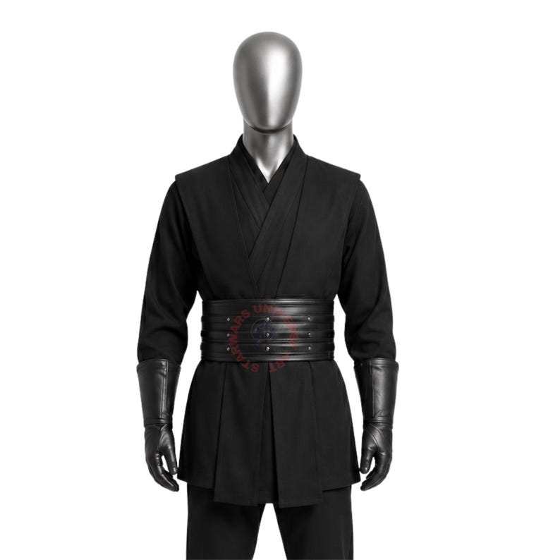 May include: A black long-sleeved tunic with a wrap-style front, paired with a wide black multi-layered belt featuring horizontal stitching and small metal studs. The outfit includes black forearm-length gloves and matching black trousers.