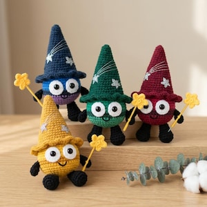 Peut inclure: Quatre figurines crochetées avec des chapeaux pointus, chacune dotée de grands yeux blancs, de pupilles noires et de pieds noirs. Les figurines sont bleu marine, vertes, bordeaux et jaunes, tenant une baguette étoilée.