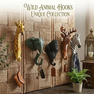 Puede incluir: Una colección de cinco ganchos de pared con forma de cabezas de animales que incluyen una jirafa, un elefante, un gorila, un ciervo y una cebra. El texto "WILD ANIMAL HOOKS UNIQUE COLLECTION" aparece sobre los ganchos para colgar objetos.