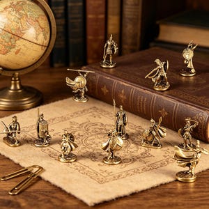 May include: A collection of small, gold-colored warrior figurines, each with unique poses and weaponry, such as swords, shields, and spears. The figurines are arranged on a tan surface with a vintage book and globe in the background.