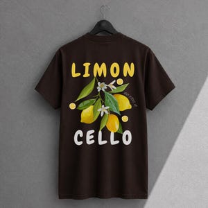 K&ouml;nnte beinhalten: Ein dunkelbraunes Kurzarm-T-Shirt mit einem Grafikdruck aus gelben Zitronen, gr&uuml;nen Bl&auml;ttern und wei&szlig;en Bl&uuml;ten. Der Text LIMON ist in Gelb &uuml;ber der Grafik gedruckt, und der Text CELLO ist in Wei&szlig; unter der Grafik gedruckt.