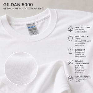K&ouml;nnte beinhalten: Ein wei&szlig;es Gildan 5000 Premium-T-Shirt aus schwerer Baumwolle mit Rundhalsausschnitt und abrei&szlig;barem Etikett. Das Shirt besteht aus 100% US-Baumwolle, hat eine klassische Passform, robuste Doppeln&auml;hte und ein Stoffgewicht von 180 g/m2.