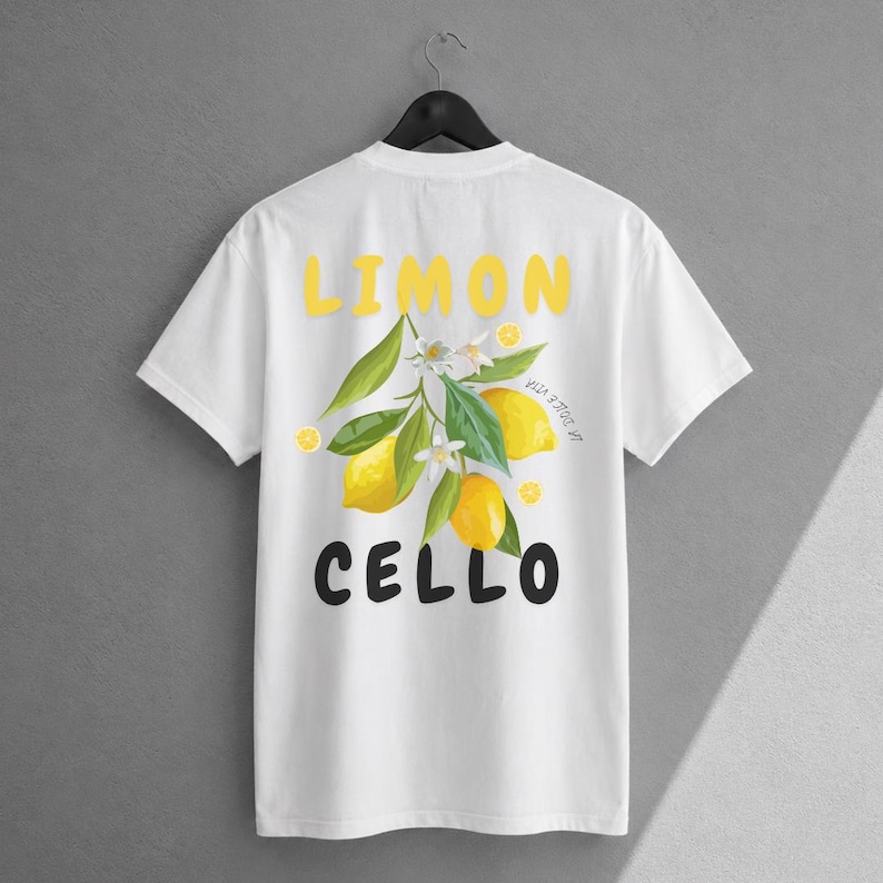 K&ouml;nnte beinhalten: Ein wei&szlig;es kurz&auml;rmeliges T-Shirt mit einem Grafikdruck auf der R&uuml;ckseite. Das Design zeigt den gelben Schriftzug LIMON oben und den schwarzen Schriftzug CELLO unter einer zentralen Illustration eines Zitronenzweigs mit Bl&auml;ttern.